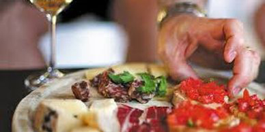 A person cutting food on top of a plate.