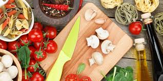 A cutting board with mushrooms and tomatoes on it