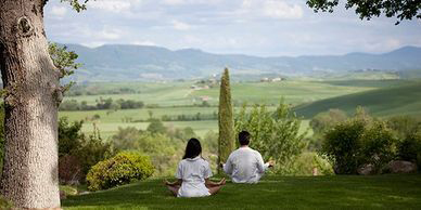 Two people sitting on the grass in a field