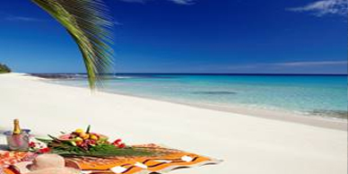 A beach with an ocean view and a picnic blanket.