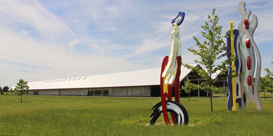 A sculpture of an ostrich in the grass.