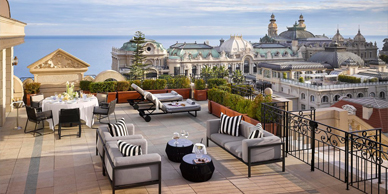 A large deck with furniture and a view of the ocean.